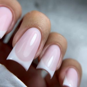 Manicura francesa moderna en uñas cuadradas con esmalte brillante.